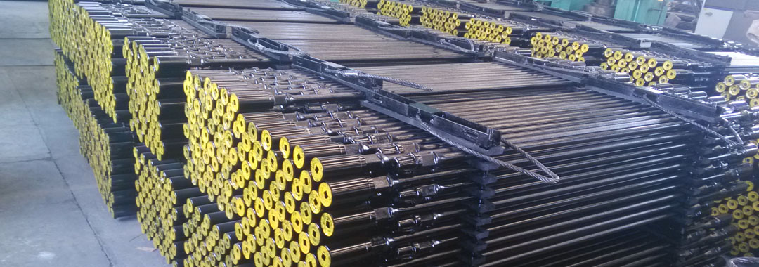 Several bundles of hollow sucker rods with yellow painted on the plastic protector.